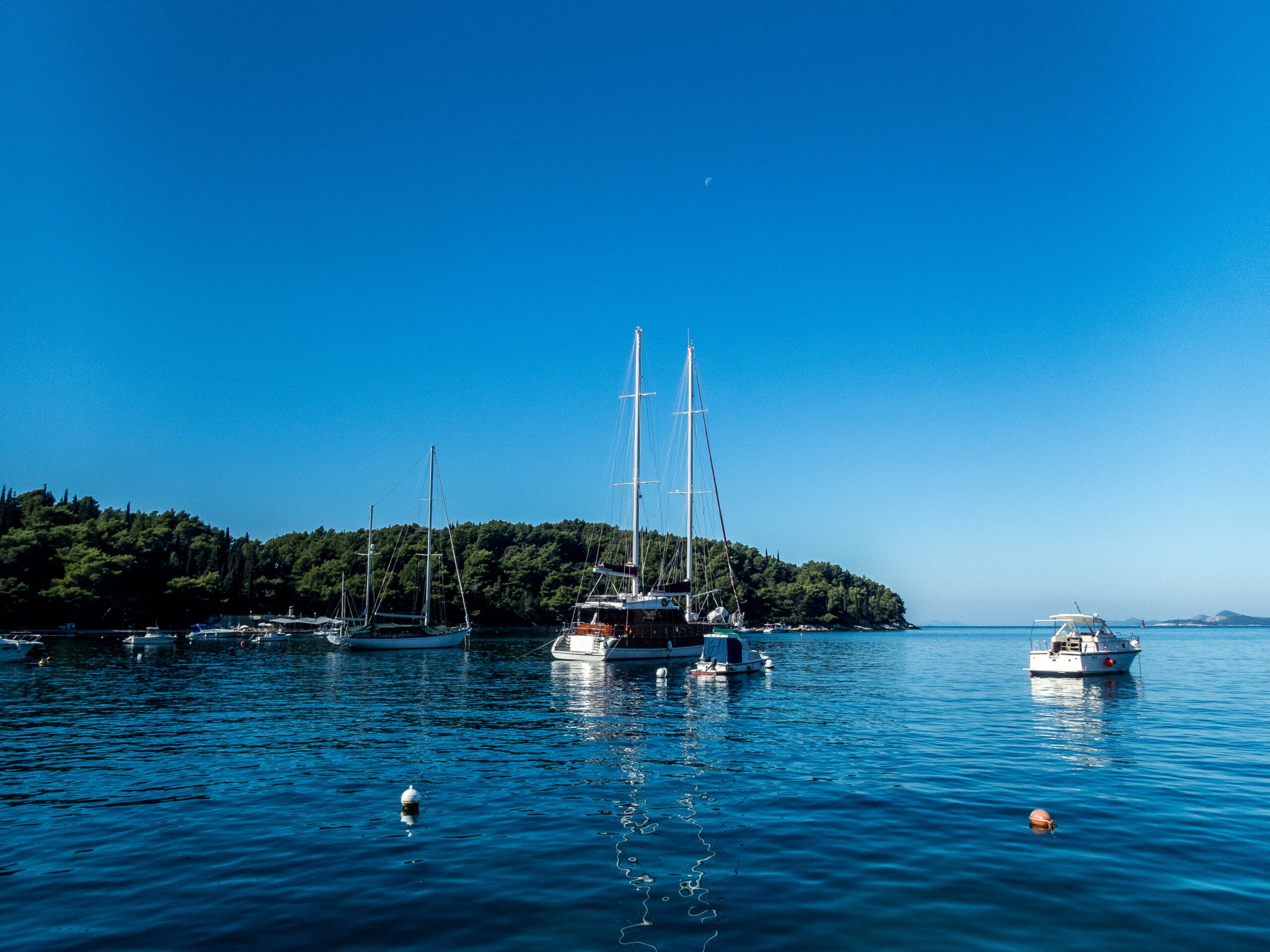 Sailboats moored in the calm waters of Sivota Greece